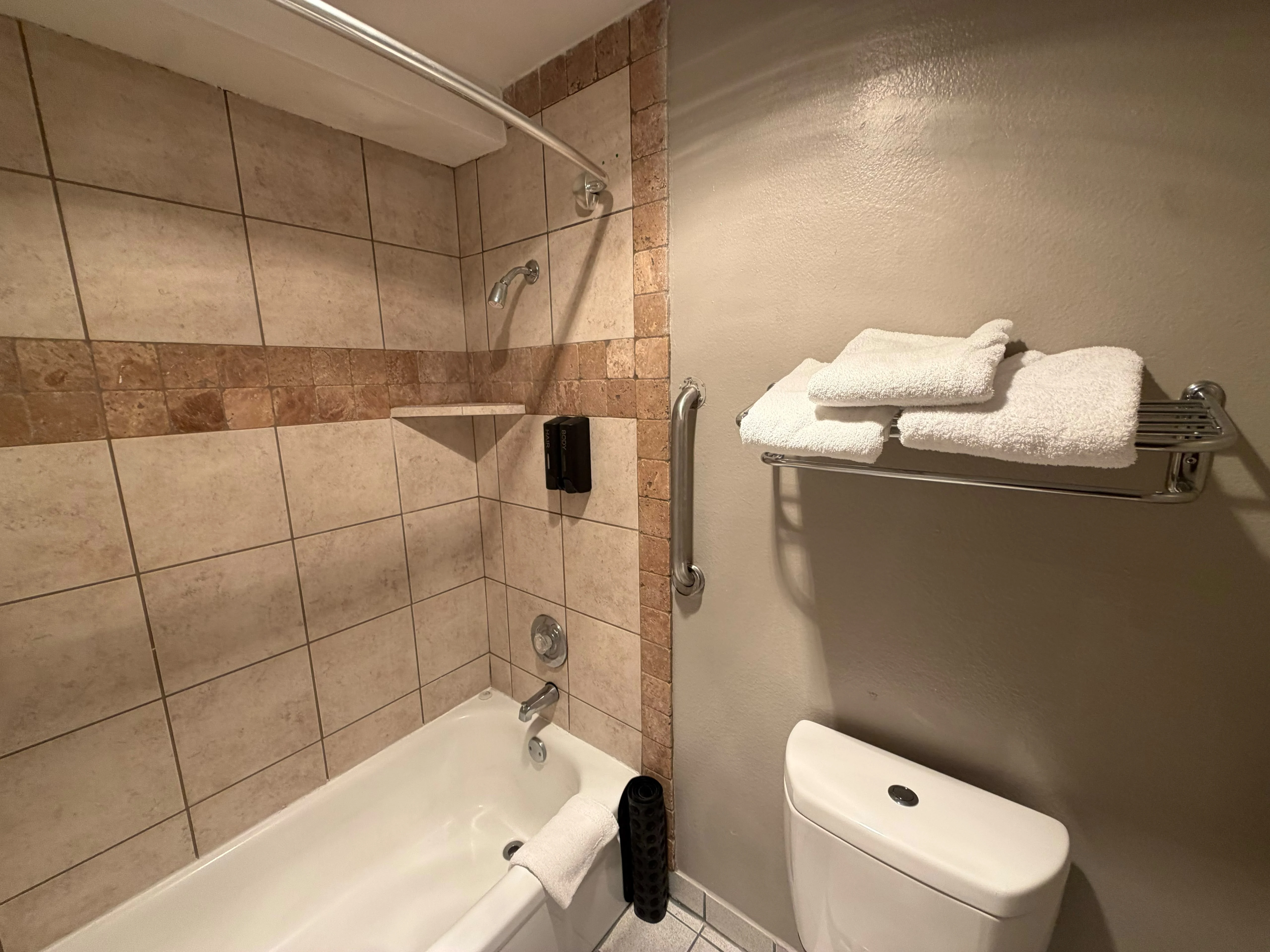 Guest bathroom with tiled bathtub and shower
